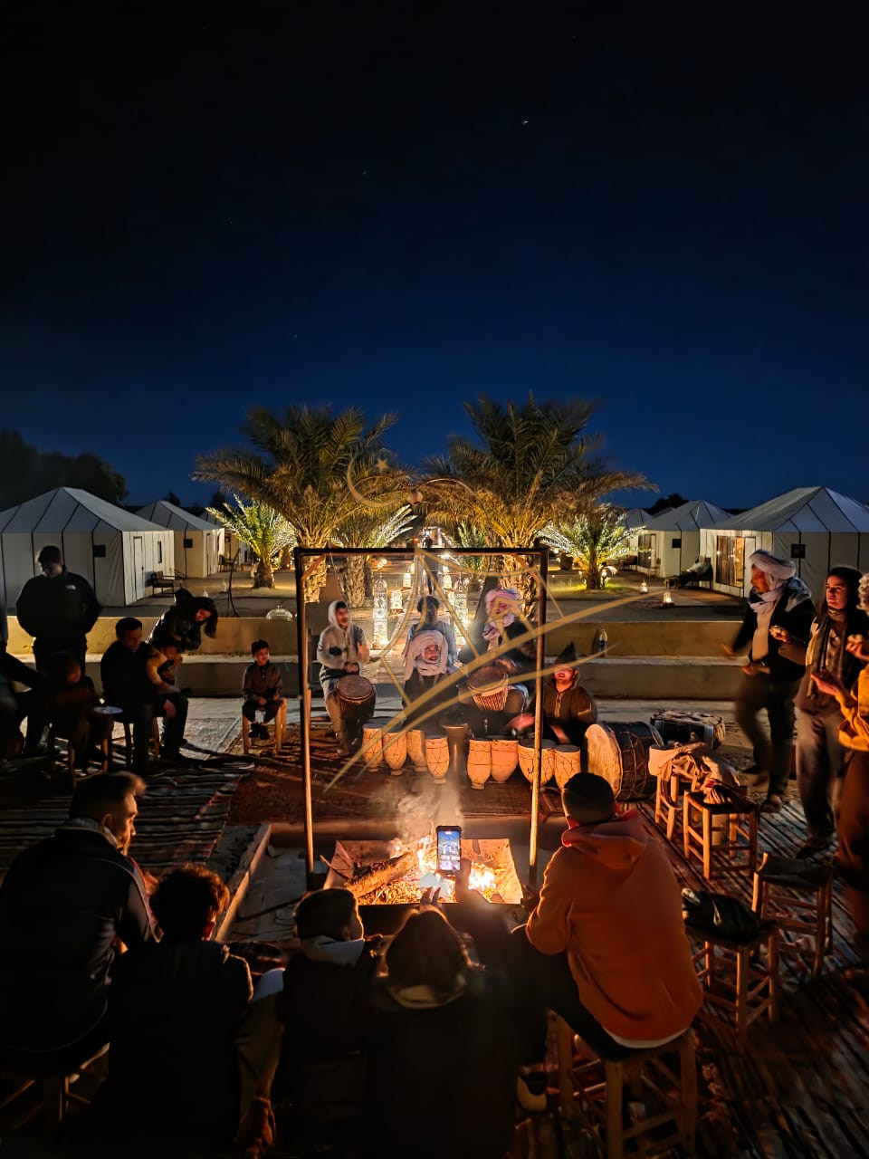 Berber drum circle performing for guests around the fire pit under the stars