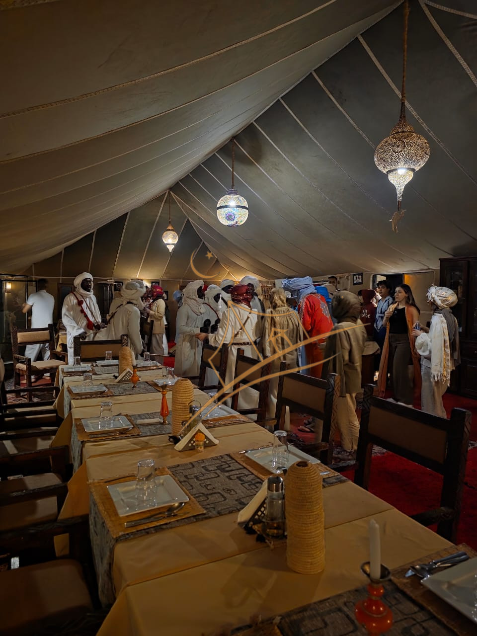 Guests and traditionally dressed staff gathered in the lantern-lit dining tent