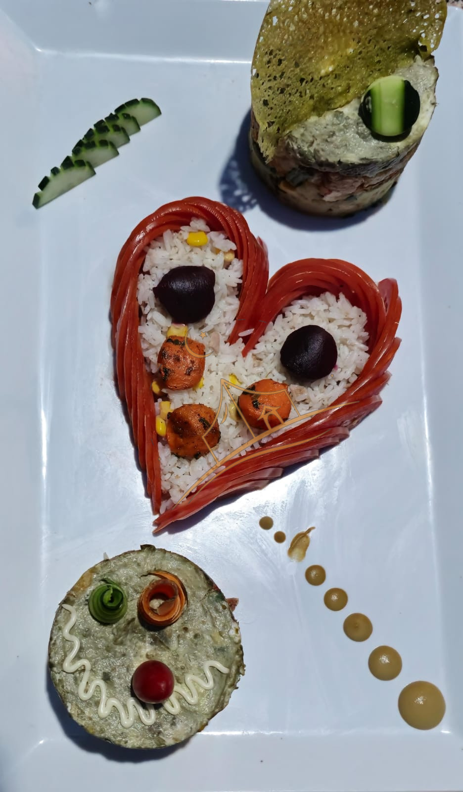Heart-shaped rice presentation with a smoked salmon roll and herb sauce dots